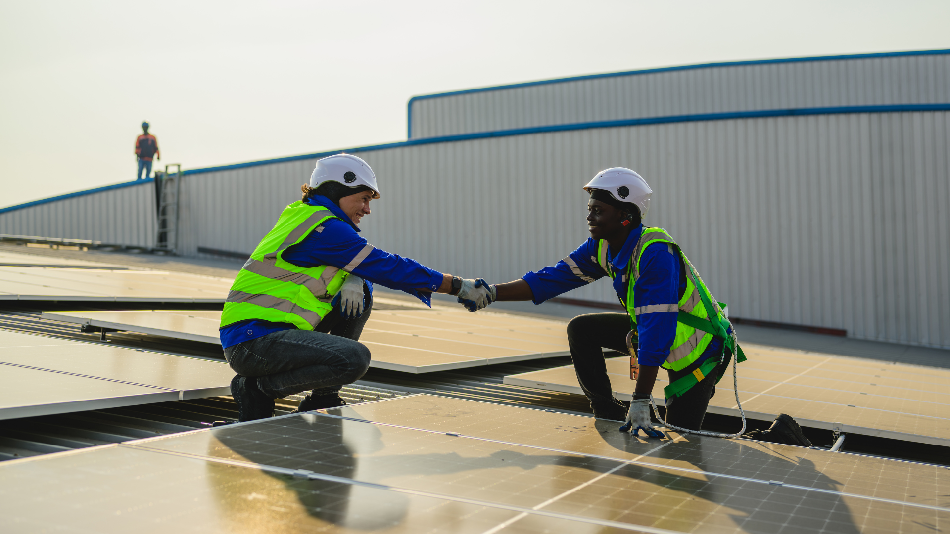 Solar technicians shaking hands on a rooftop installation